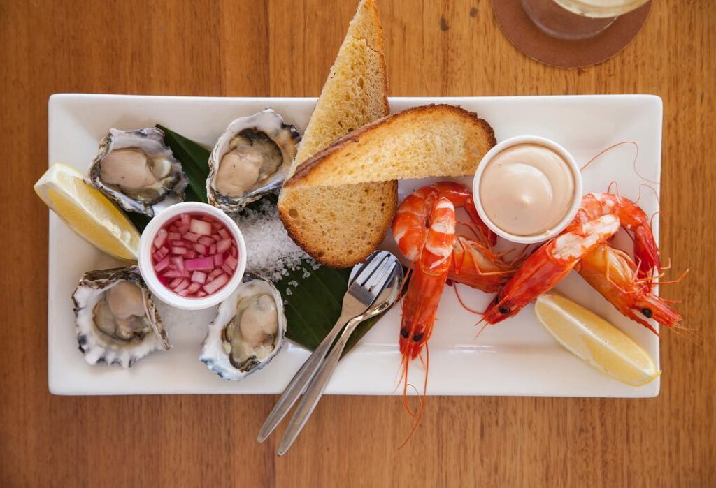 Plate of oysters with bread and prawns.